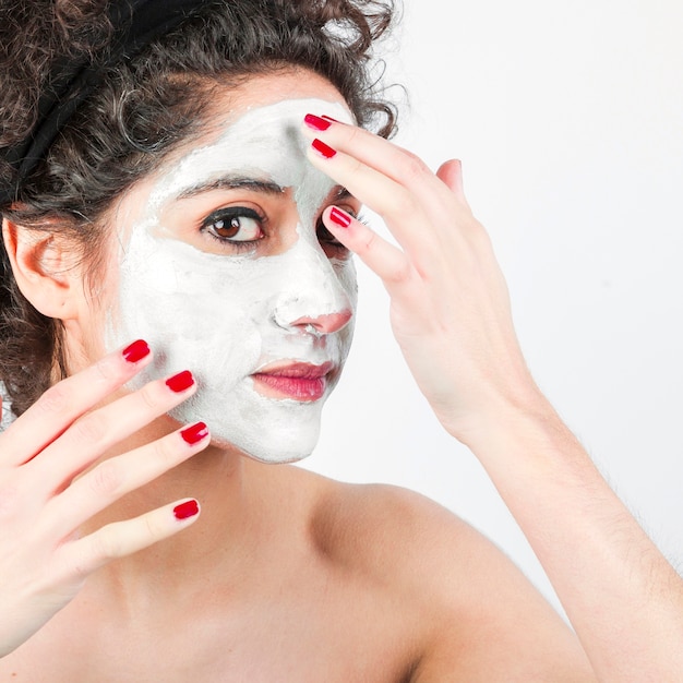 1365819 woman applying face mask her face against white background23 2147901162