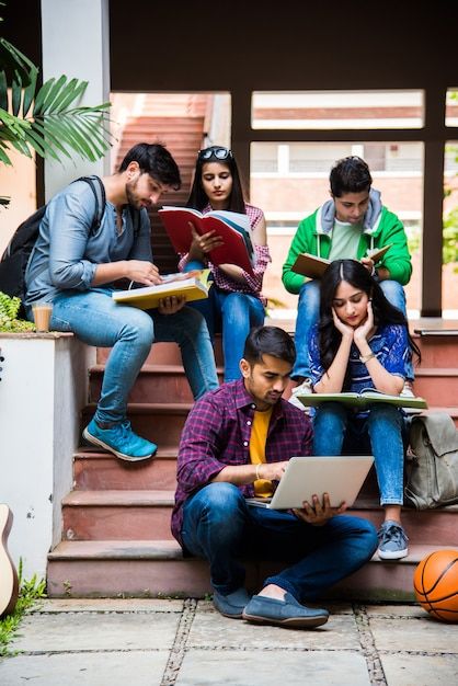 1391287 Premium Photo Young Asian Indian college students reading books studying on laptop preparing for exam or working on group project while sitting on grass staircase or steps of college campus 1
