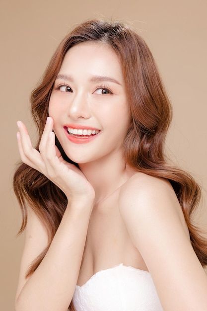 1396663 Premium Photo Young Asian beauty woman curly long hair with korean makeup style touch her face and perfect skin on isolated beige background Facial treatment Cosmetology plastic surgery