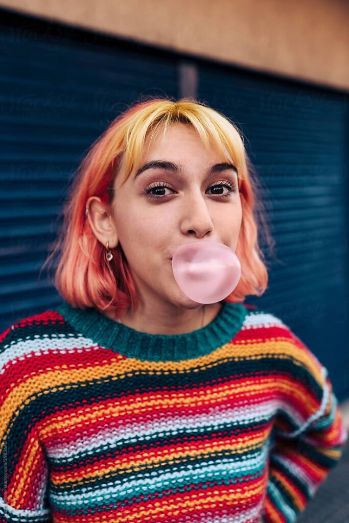1402203 Gen Z Woman Chewing Gum by Stocksy Contributor Lucas Ottone