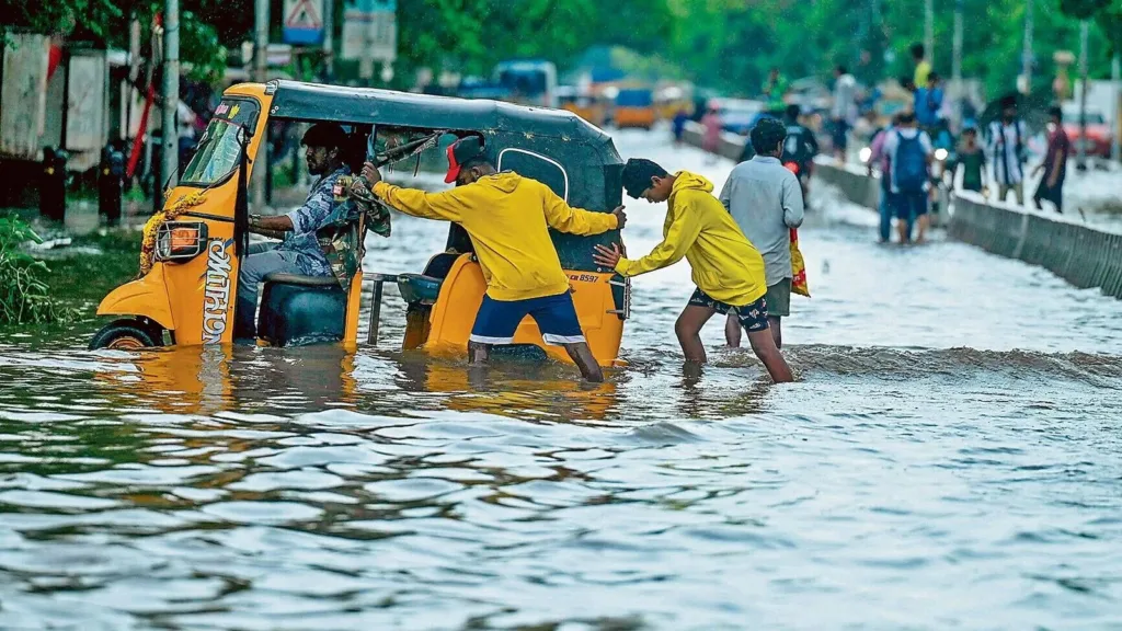 1409819 People push an auto rickshaw stuck on a flooded st17292198595651729219873280